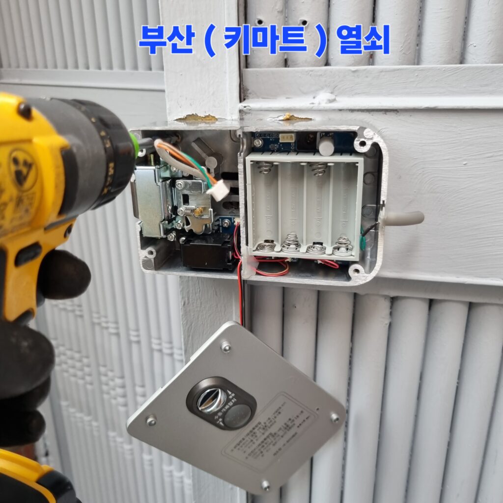 배터리 수납 및 수동 개폐 제어 장치가 포함된 내측 기기 하우징을 대문 프레임에 견고하게 밀착 고정하는 조립 단계입니다.
